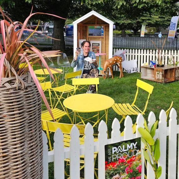 A person sitting at a table in the Palmy Proud Farmer's Market area