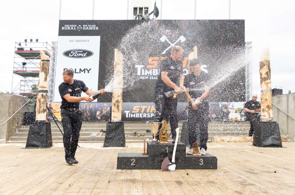 Timbersports winners podium unloading three bottles off champaign